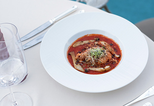 Ein Teller rote Suppe mit Fleischeinlage